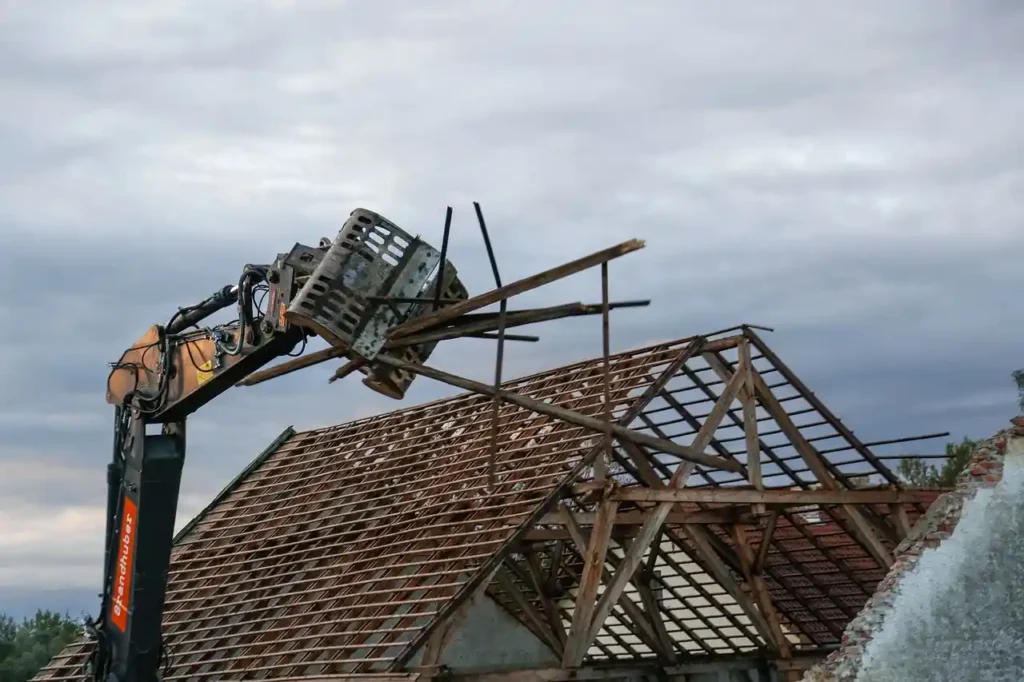 Excavator demolishing the house roof