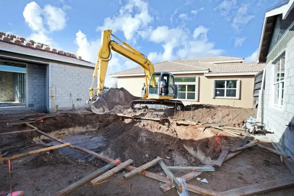 Yellow excavator demolishing a building